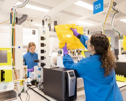 Scientists in protective gear working in the cell and gene therapy lab. They are setting up prodigy