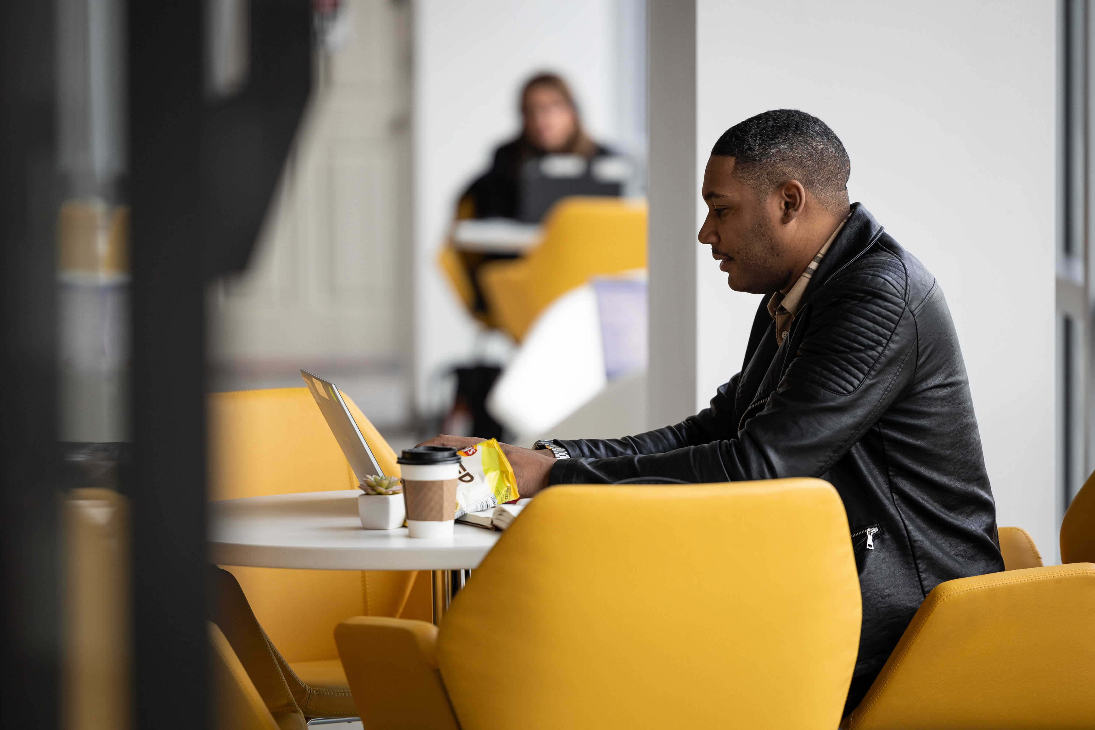 An employee working on his laptop in the office cafe