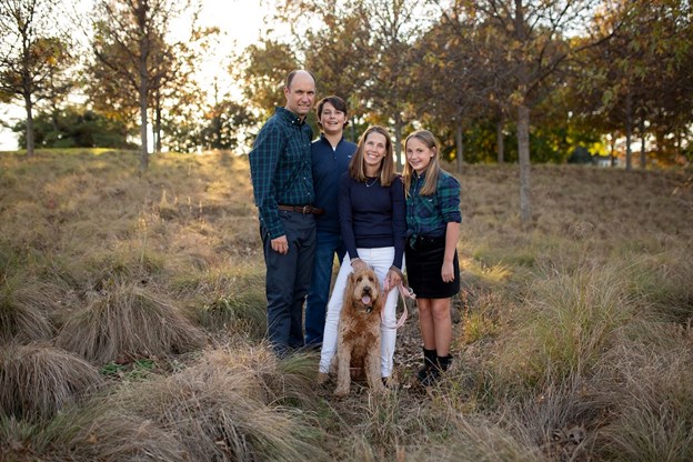 family with dog in field 
