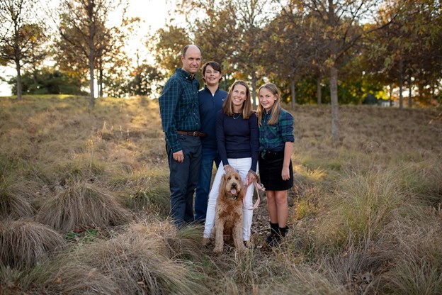 family with dog in field