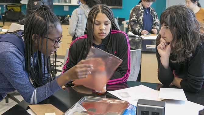 Three students collaborating in science class