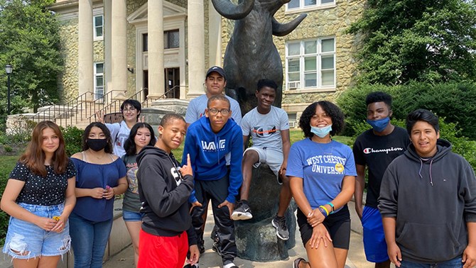 Group of students in front of a ram statue