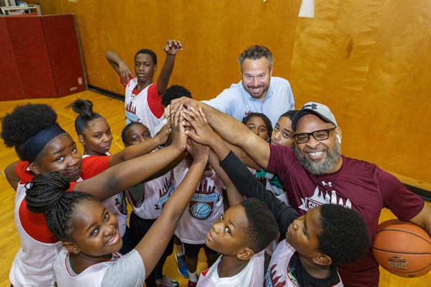 Young teens gathering their hands together before a basketball game 