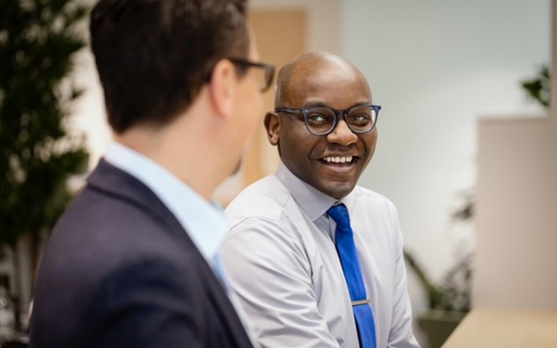 two male employees laughing in the office