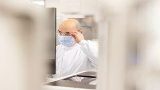 Lab worker adjusting glasses