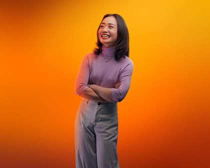 Female laughing with orange background