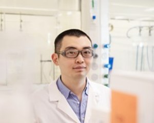 Scientist wearing a lab coat looking at the camera