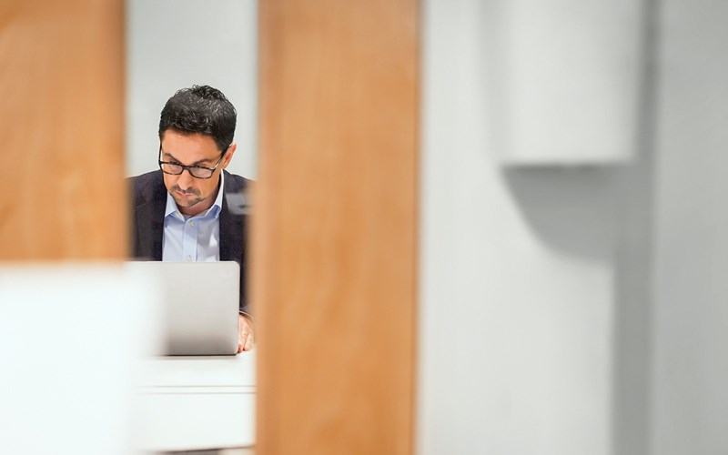 Men in office looking at his laptop.