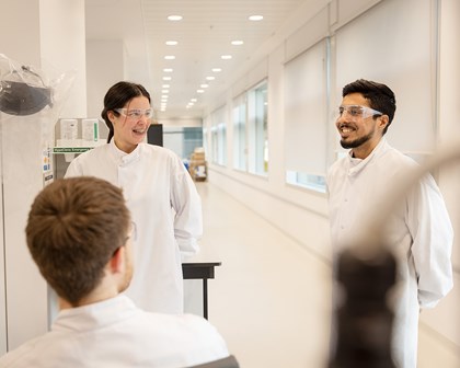 Team of scientists in lab coats collaborating in a lab 