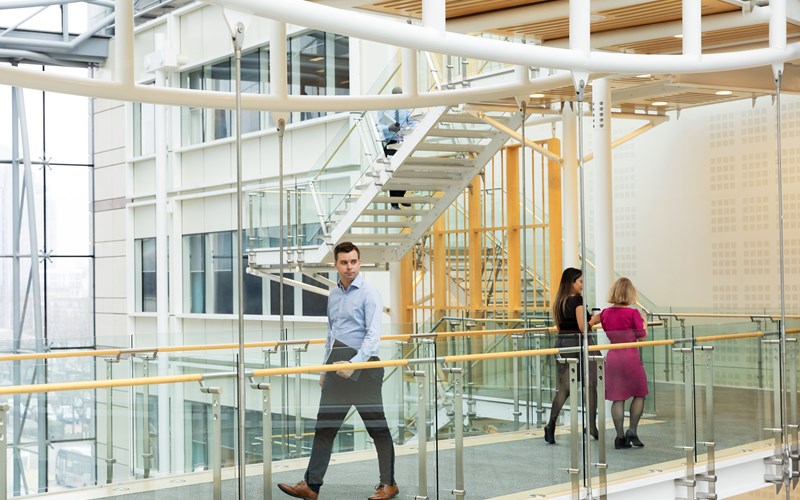 male walking over bridge in the office 