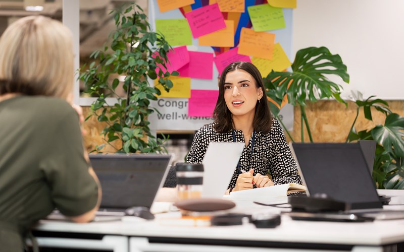 female in the office talking to other colleague.