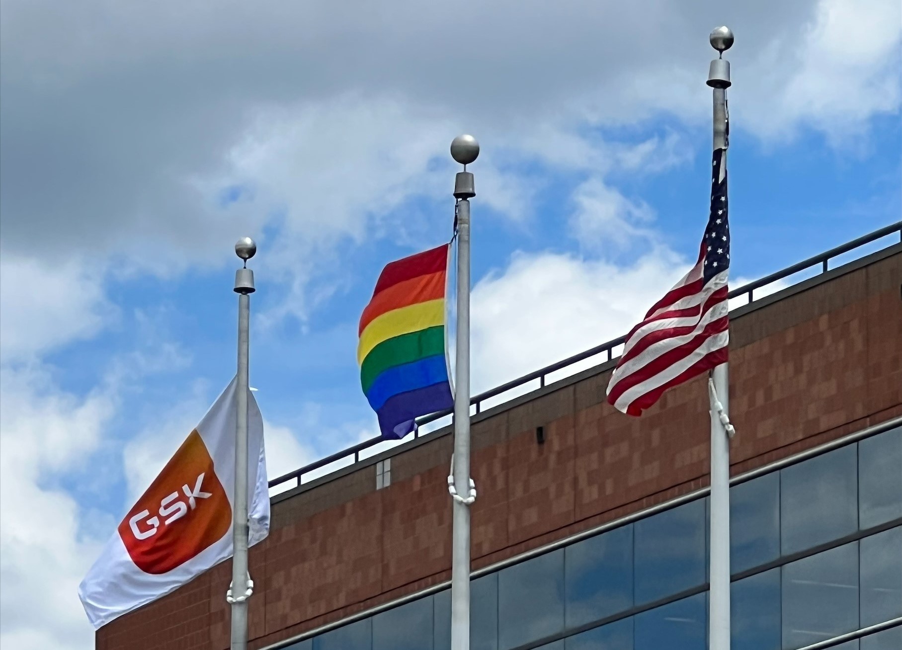 three flags: GSK, LGBTQIA and US