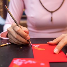 hands painting a red envelope. 
