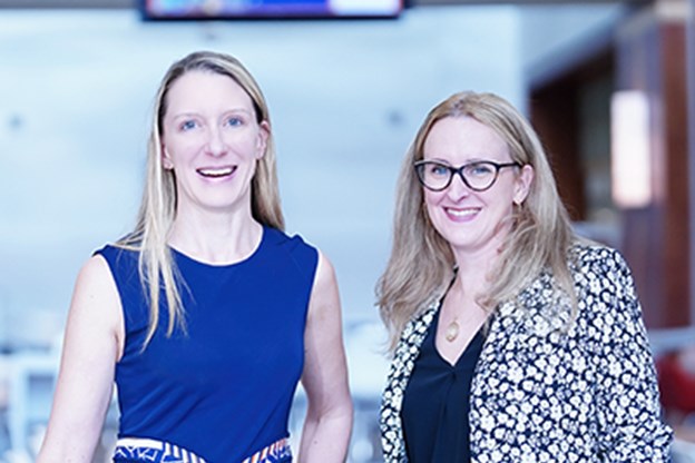 Two female scientists smiling at the camera