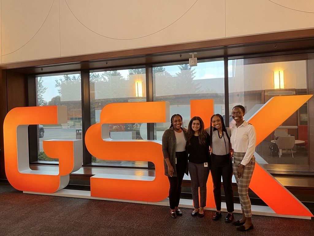 4 female students in front of the GSK sign.