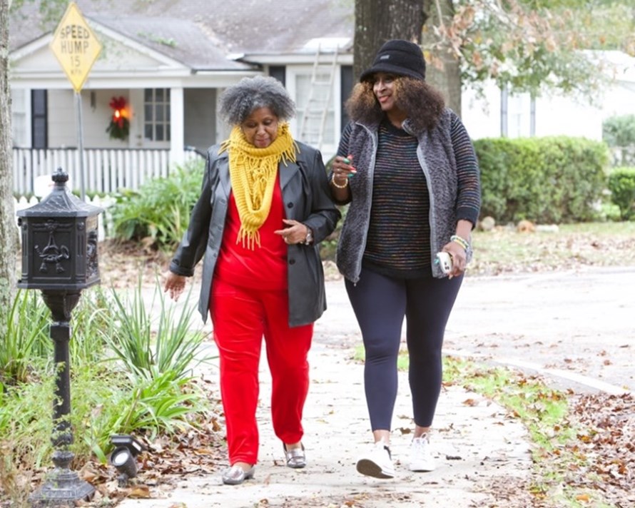 two women walking in a neighborhood. 
