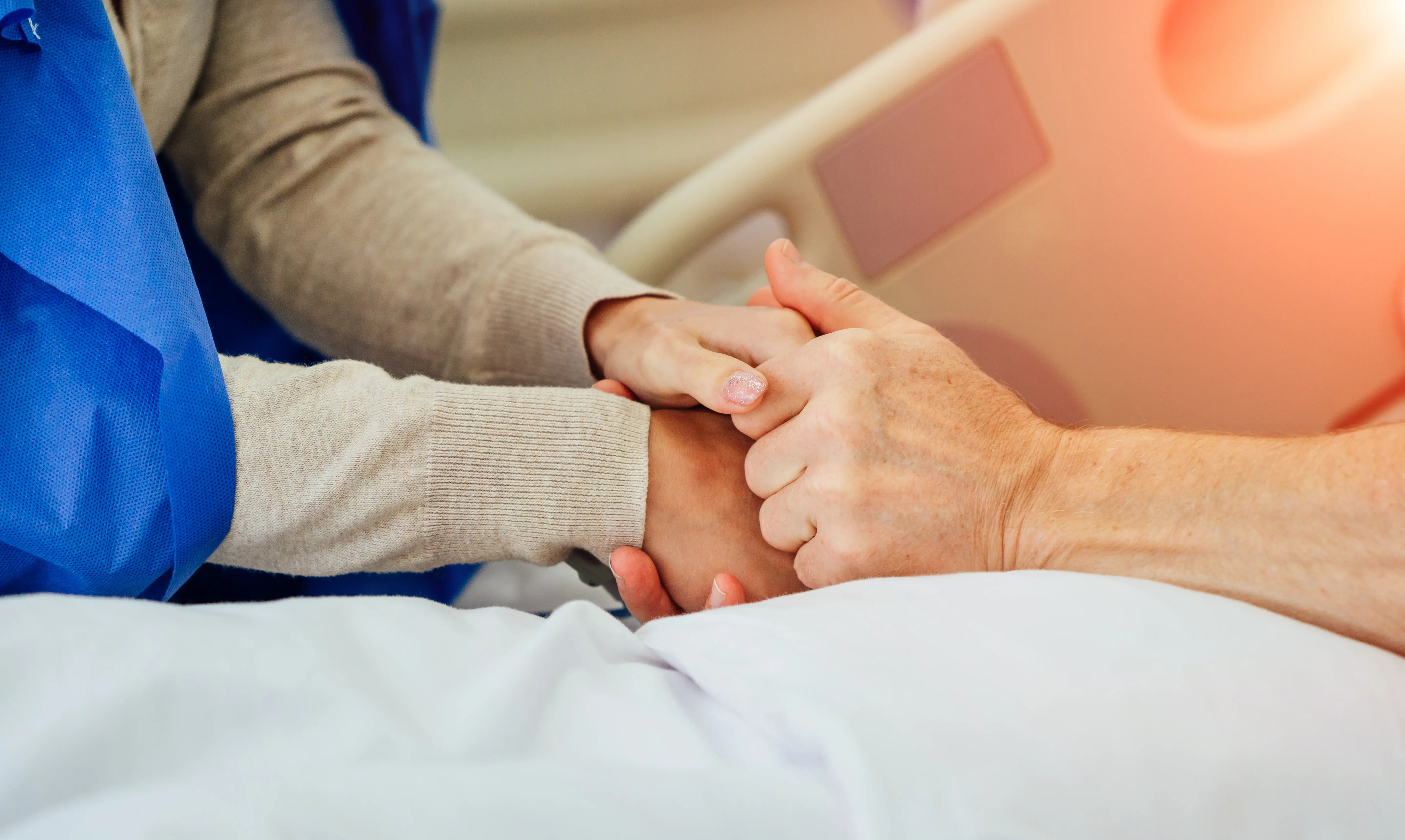 nurse and patient holding hands.