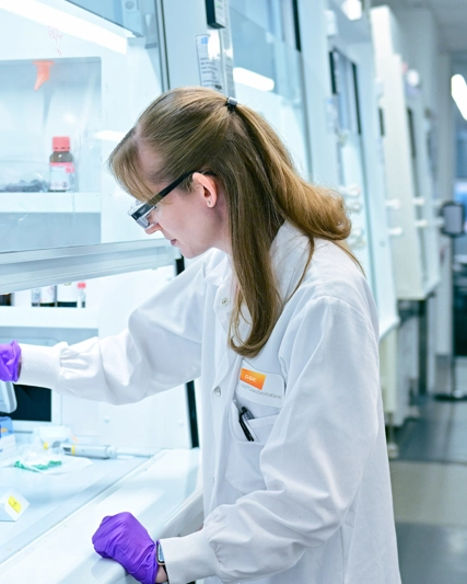 Nicole is a scientist in a lab coat working in the lab