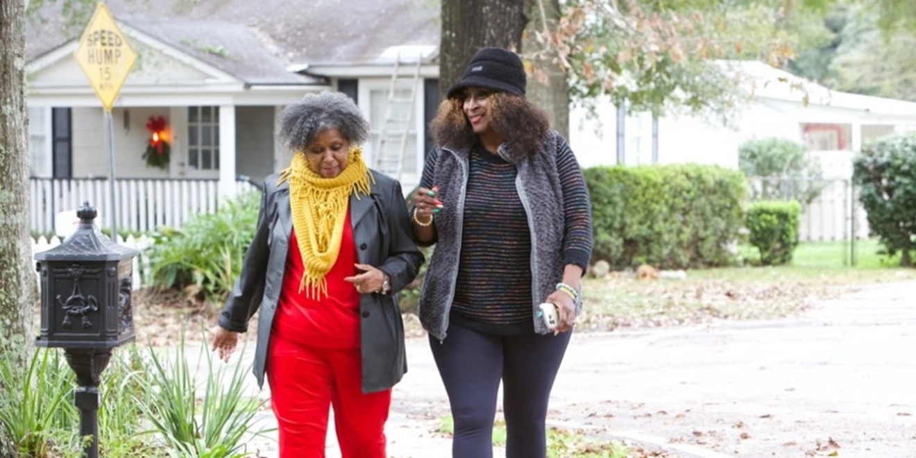 two women walking in a neighborhood.