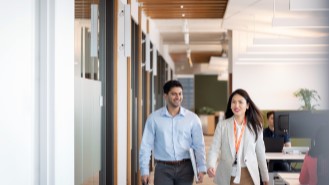 Two people walking in an office