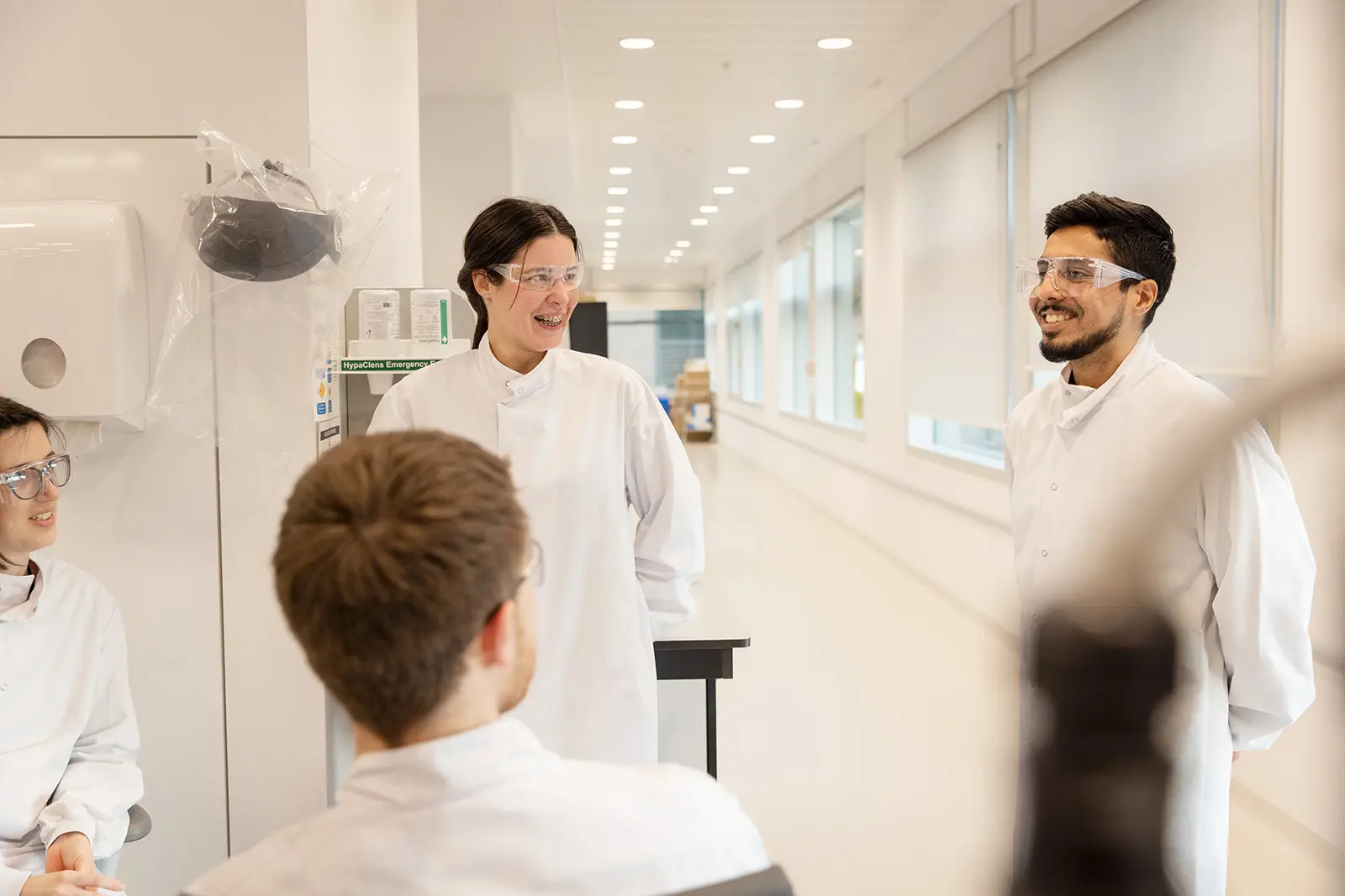 Team of scientists in lab coats collaborating in a lab