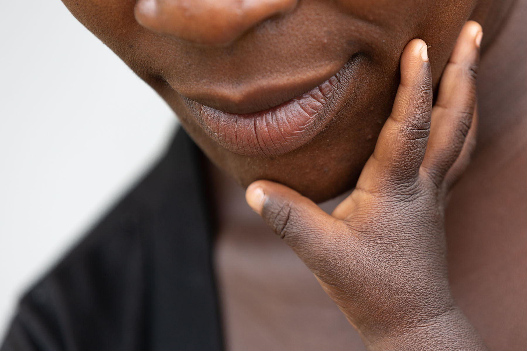 baby hand touching the chin of their mother