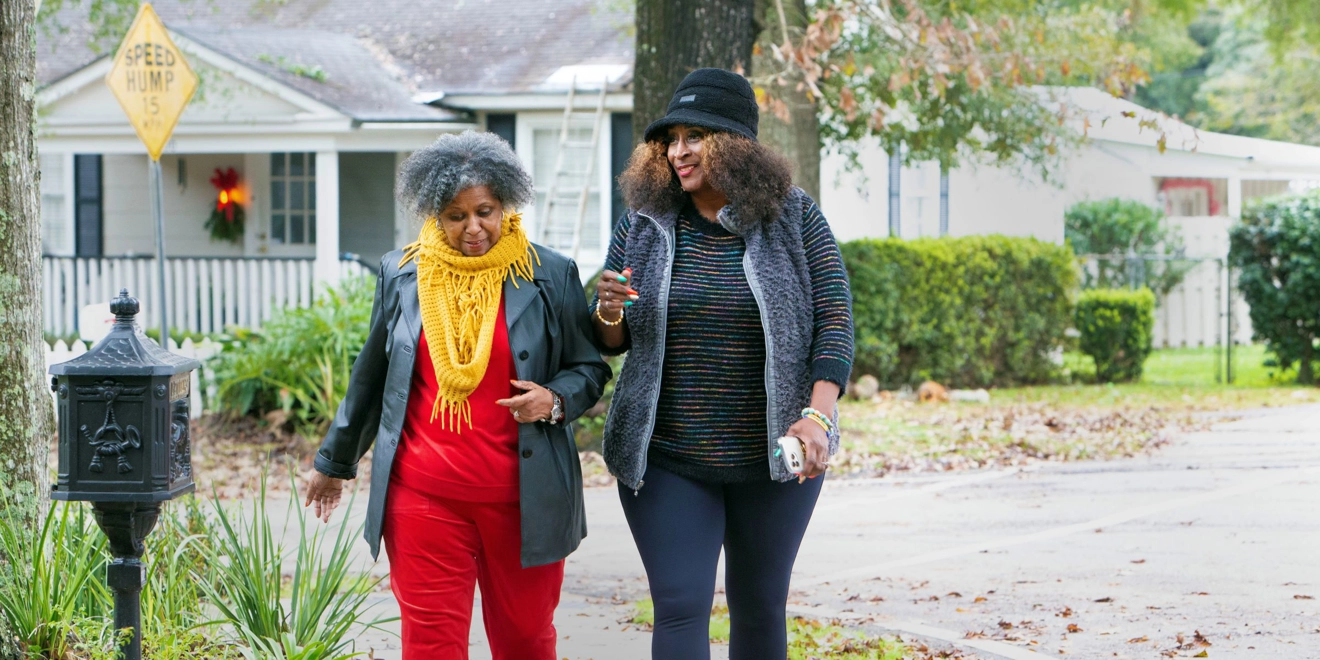 two women walking in a neighborhood.