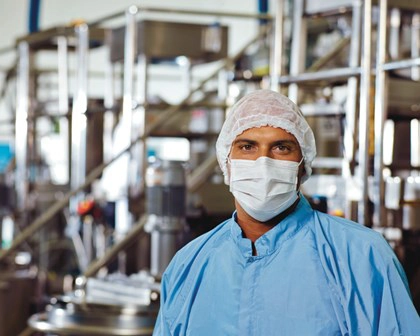 man wears dust mask and hair net in plant