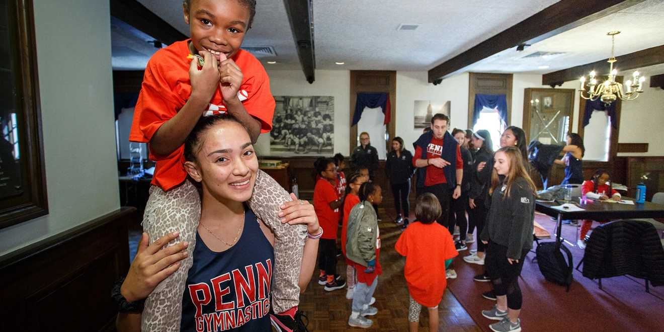 Young girl on the shoulders of an older teenage girl after a gymnastics class