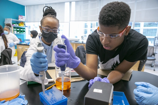 two black students using lab equipment.