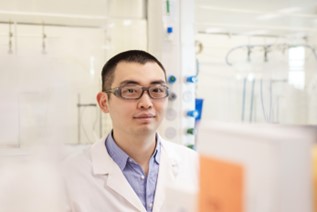 Scientist wearing a lab coat looking at the camera