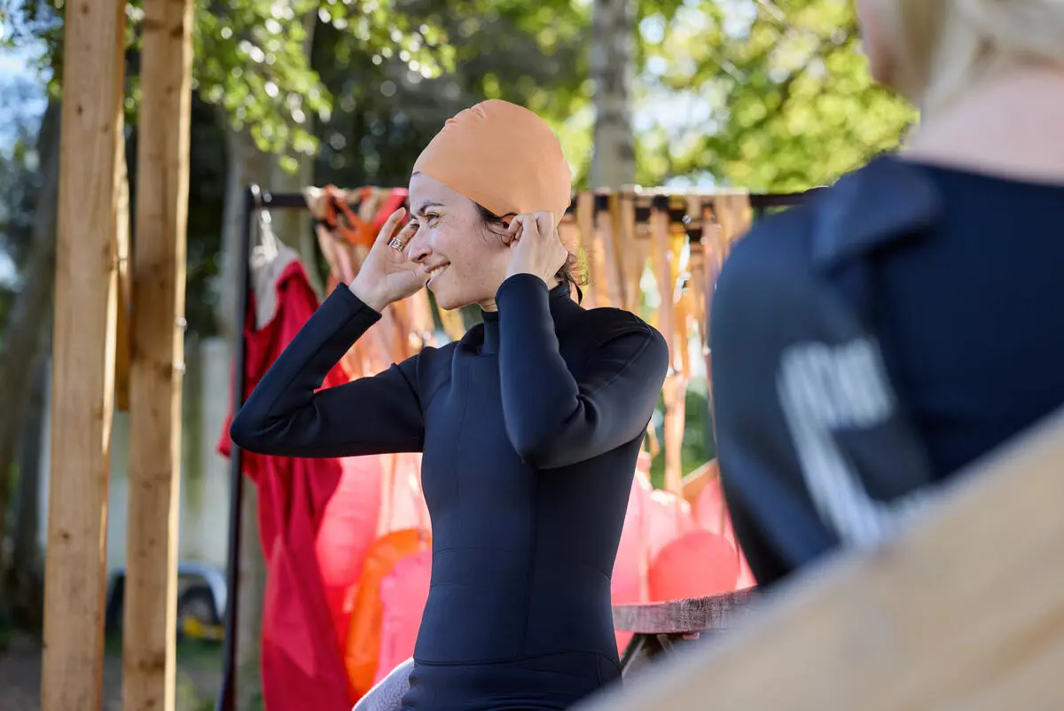 Woman putting on swim cap.