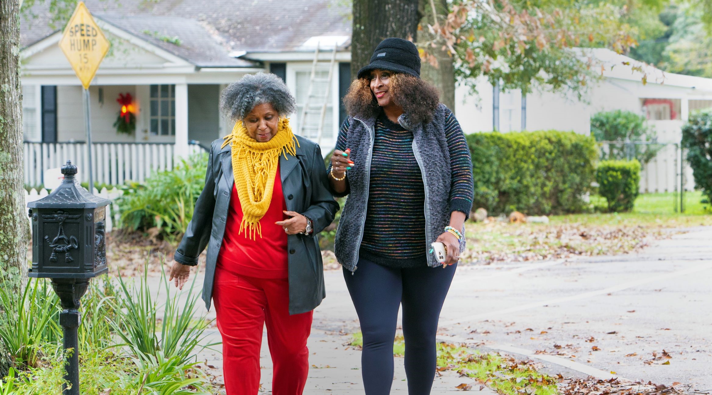 two women walking in a neighborhood. 