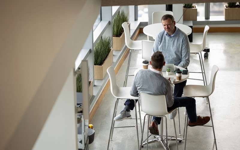 Two employees discussing work in the office cafe
