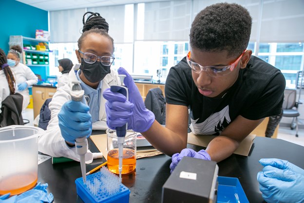two black students using lab equipment.
