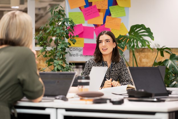 female in the office talking to other colleague.