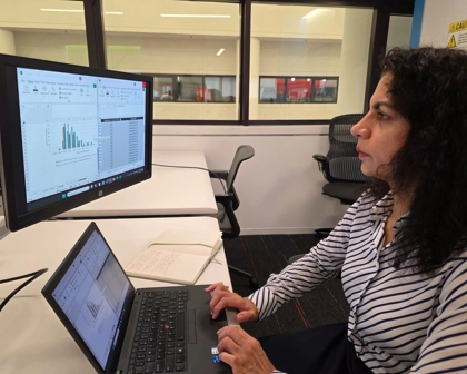 Renuka working in office in front of her computer.