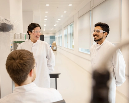 Team of scientists in lab coats collaborating in a lab