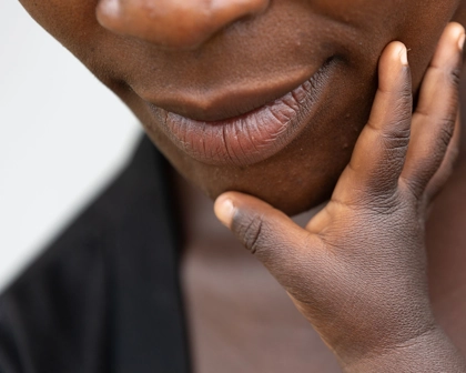 baby hand touching the chin of their mother