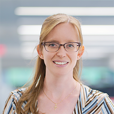 Nicole is wearing glasses, smiling at the camera.